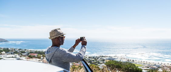 A man takes a photo from his car of a nice sunny beach